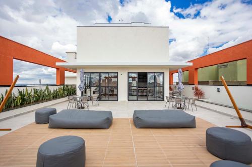 - un toit-terrasse avec des chaises et des tables dans un bâtiment dans l'établissement Edificio MUV Yogha, à Curitiba