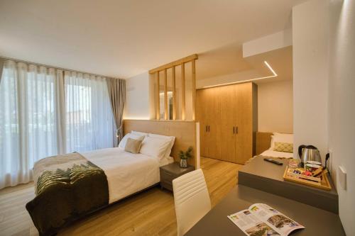 a hotel room with a bed and a desk at La Corte Delle Dolomiti in Agordo