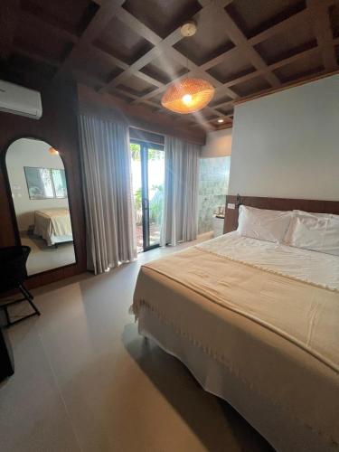 a bedroom with a large bed and a large mirror at Pousada Cancun Boutique in Guarujá