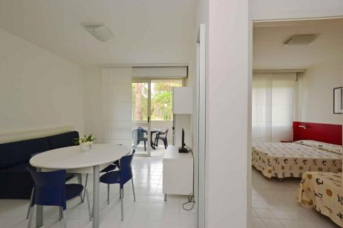 a room with a table and a bed and a bedroom at Apartments in Lignano 21597 in Lignano Sabbiadoro