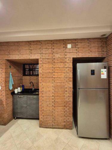 een keuken met een roestvrijstalen koelkast en een bakstenen muur bij B&B rooms in Tbilisi City