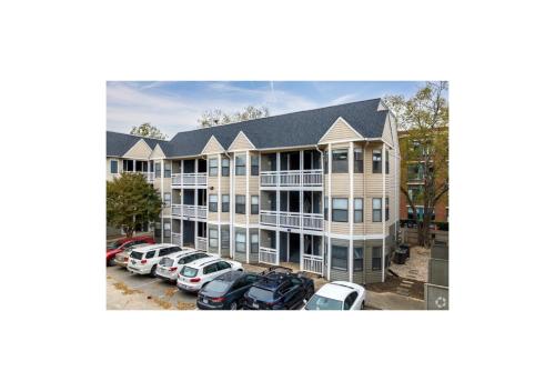 an apartment building with cars parked in a parking lot at The Serene Uptown Flat in Charlotte