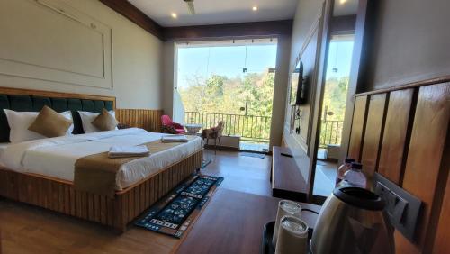 a bedroom with a bed and a large window at Corbett Mid Forest House By Havensia Stays in Rāmnagar