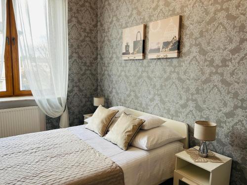 a bedroom with a white bed and a window at Apartamenty Roztocze in Zwierzyniec