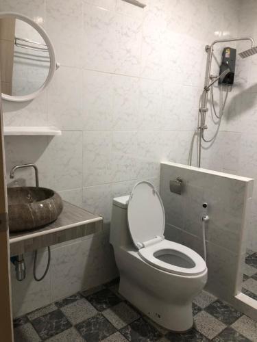een badkamer met een toilet, een wastafel en een spiegel bij The Sun homestay in Ko Kood