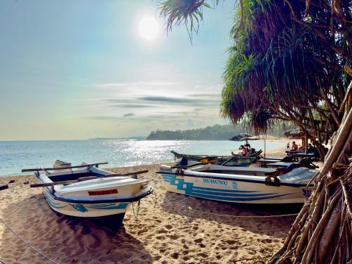 タンガラにあるSouthern Nest Villa Tangalleの三隻の船が海辺に座っている