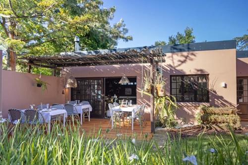 サマーセット・ウェストにあるAfrica Lodgeの庭園内のテーブルと椅子付きのレストラン