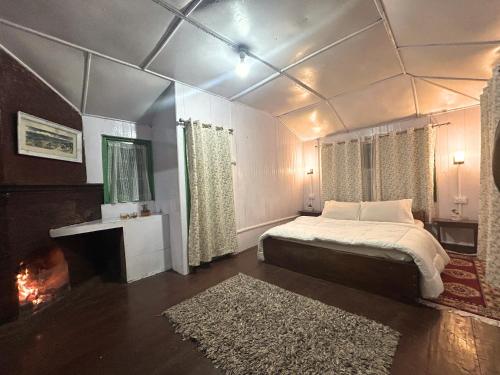 a bedroom with a bed and a fireplace in it at Mim Tea Estate Residency A 1920 Heritage Darjeeling Tea Garden Home in Sukhia Pokhari