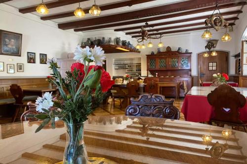 ein Wohnzimmer mit einer Vase mit Blumen auf einem Tisch in der Unterkunft Hotel Bären Meersburg in Meersburg
