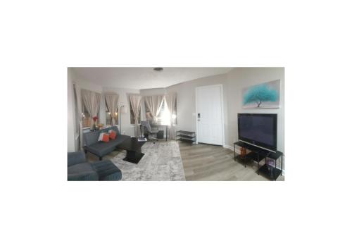 The Serene Uptown Flat في تشارلوت: غرفة معيشة مع أريكة وتلفزيون