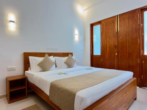 タンガラにあるSouthern Nest Villa Tangalleのベッドルーム1室(大型ベッド1台、木製家具付)