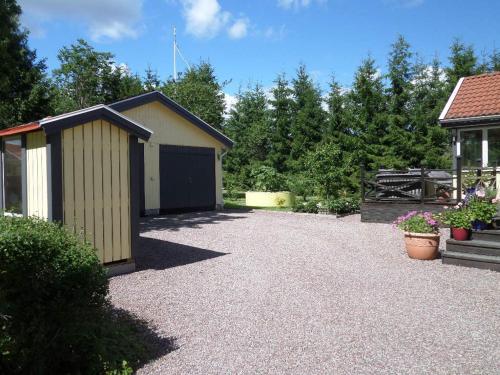 a gravel driveway with a shed next to a house at Skogis Bed & Breakfast in Katrineholm
