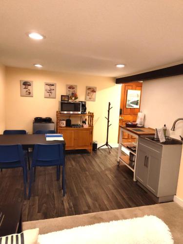 a living room with a table and blue chairs at Sweet Beech St Retreat-Basement Apt in Portland