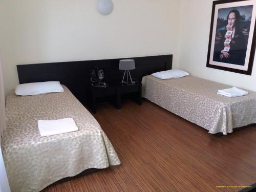 a room with two beds and a table with a picture at Pensiunea Play in Deva