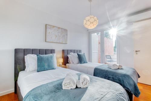 a bedroom with two beds with towels on them at Vita Portucale ! Aroeira 4 Bdr Pool & Golf Retreat in Aroeira