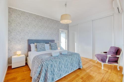 a bedroom with a bed and a purple chair at Vita Portucale ! Aroeira 4 Bdr Pool & Golf Retreat in Aroeira