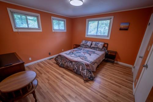 een slaapkamer met oranje muren en een bed en een tafel bij Dragon's Lair in Robbinsville