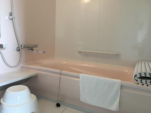 a bathroom with a bath tub with a towel on it at Petit Hotel Blanc Fleur in Nakafurano