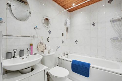 a bathroom with a sink and a toilet and a bath tub at The Skyline Suite Tottenham in London