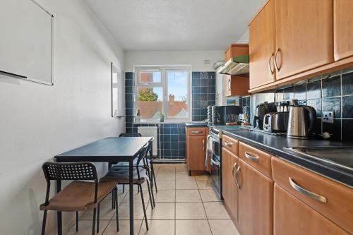 a kitchen with a table and some chairs in it at The Skyline Suite Tottenham in London