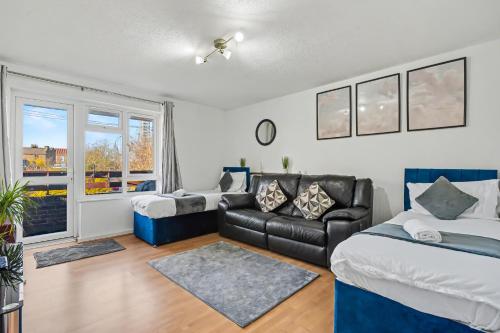 a living room with a bed and a couch at The Skyline Suite Tottenham in London