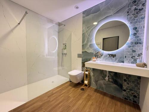 a bathroom with a sink and a toilet and a mirror at Calcedonia House - Gerês in Terras de Bouro