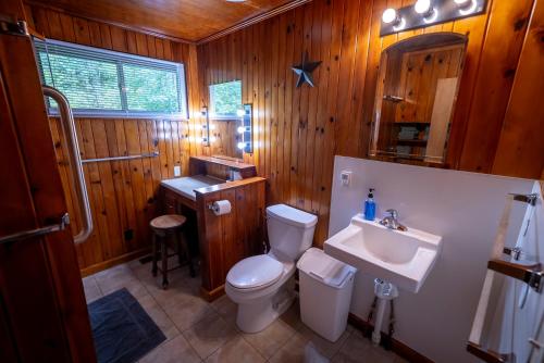 een houten badkamer met een toilet en een wastafel bij Dragon's Lair in Robbinsville