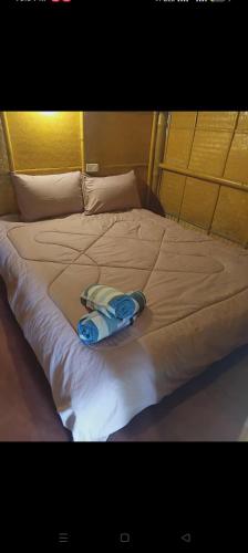 a white bed with a towel on top of it at in the palm hut in Phra Ae beach