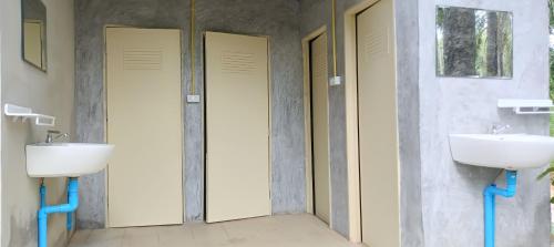 un baño con dos lavabos y dos inodoros en Bambu hut, en Phra Ae beach