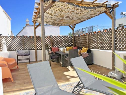 a patio with chairs and a table on a roof at Casa Alice - Olhão By Junto ao Mar in Olhão