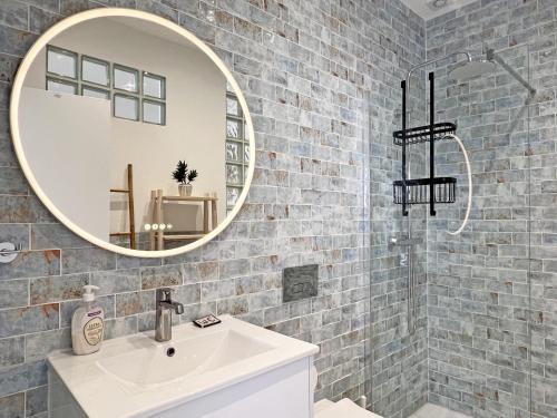 a bathroom with a white sink and a mirror at Casa Alice - Olhão By Junto ao Mar in Olhão