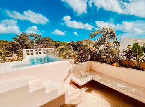 Acogedor estudio con piscina في كانكون: حمام سباحة مع مقعد بجوار