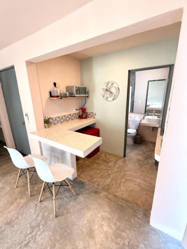 a room with a table and two chairs and a bathroom at Acogedor estudio con piscina in Cancún