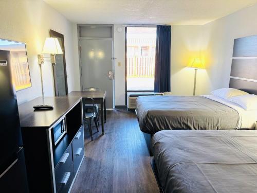 a hotel room with two beds and a desk at Newnan Nook in Newnan