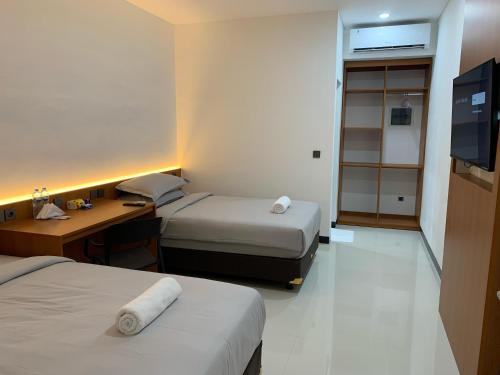 Ένα ή περισσότερα κρεβάτια σε δωμάτιο στο Passifika Hotel Maluk