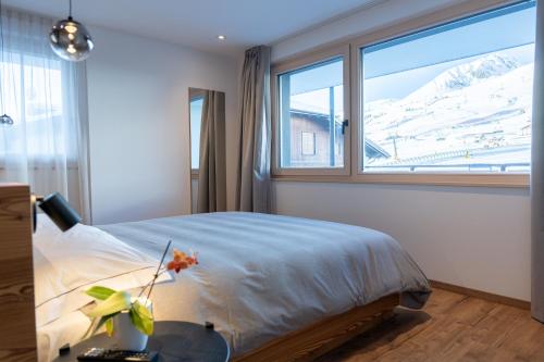 ein Schlafzimmer mit einem Bett und einem großen Fenster in der Unterkunft Le Sort Mountain Retreat in Passo del Tonale