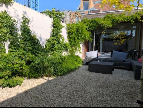 un patio con sofá y algunas plantas en De overkant, en Brujas