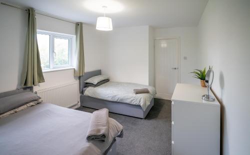 En eller flere senge i et værelse på Modern 3 Bedroom Home Ideal for Families and Business Stays