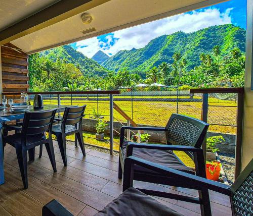un balcone con tavolo e sedie e vista di Studio Tropical - climatisé - vue mer et montagnes - canoes et paddle offerts ! Teahupo'o Lodge Tahiti a Teahupoo