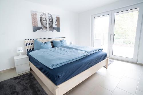 Ferienhaus nah der Ostsee, 110qm mit eigenem Garten في شاربوتس: غرفة نوم بسرير وملاءات زرقاء ونافذة