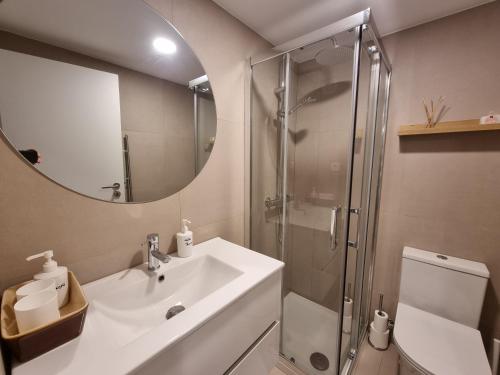 a bathroom with a sink and a shower with a mirror at Hikary in Lavra