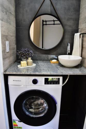 a bathroom with a washing machine and a mirror at Apart Altos de Ensueño in La Falda