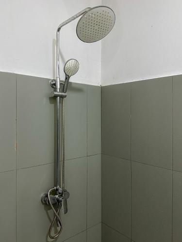 a shower with a shower head in a bathroom at Vibra Hostel in Sigiriya