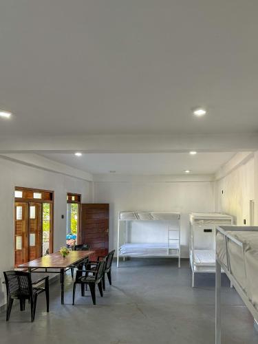 a room with a table and chairs and a bed at Vibra Hostel in Sigiriya