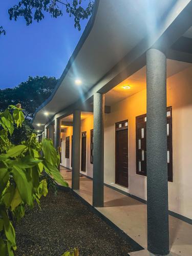 a building with pillars in front of it at night at Vibra Hostel in Sigiriya