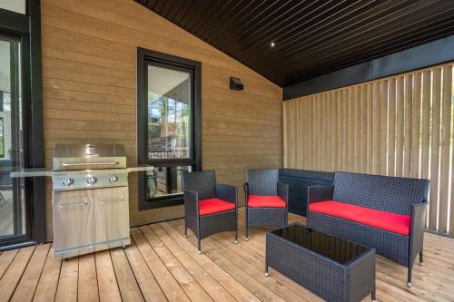 a patio with chairs and a table and a counter at Chalet du Golf avec Spa in Saint-Faustin