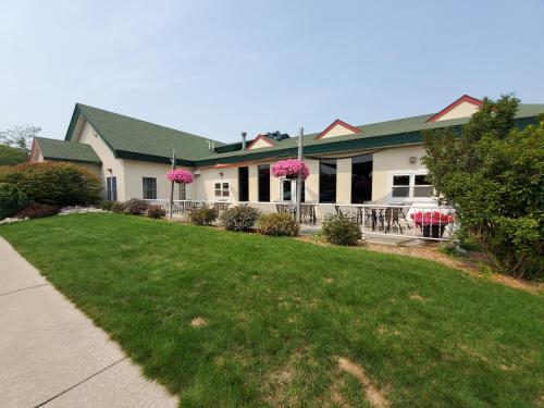 a house with a lawn in front of it at UP NORTH HOTEL formerly Voyager Inn in Saint Ignace