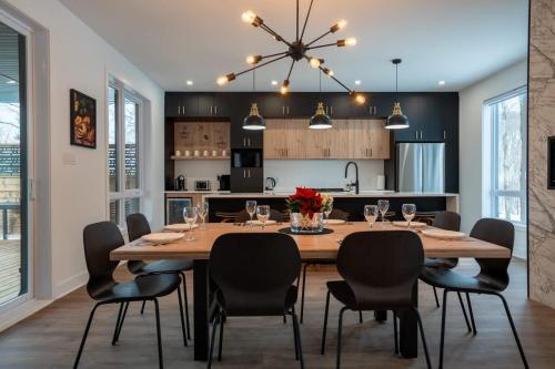 a kitchen and dining room with a large wooden table and chairs at Le Birdie spa et sauna in Saint-Faustin