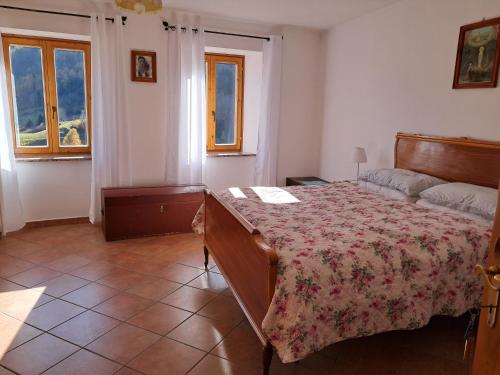 a bedroom with a bed with a floral bedspread at Casa della Nonna in Celledizzo
