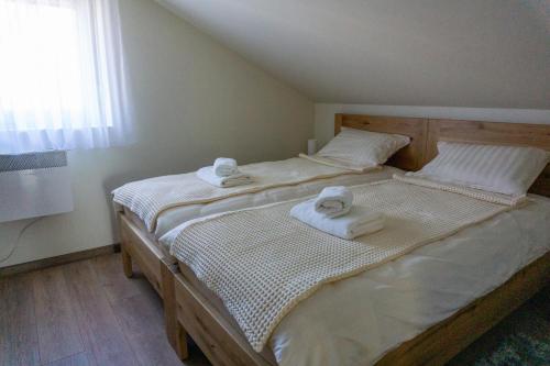 Kuća za odmor Back to Bašić في Mandičevac: غرفة نوم بها سرير مع مناشف عليه